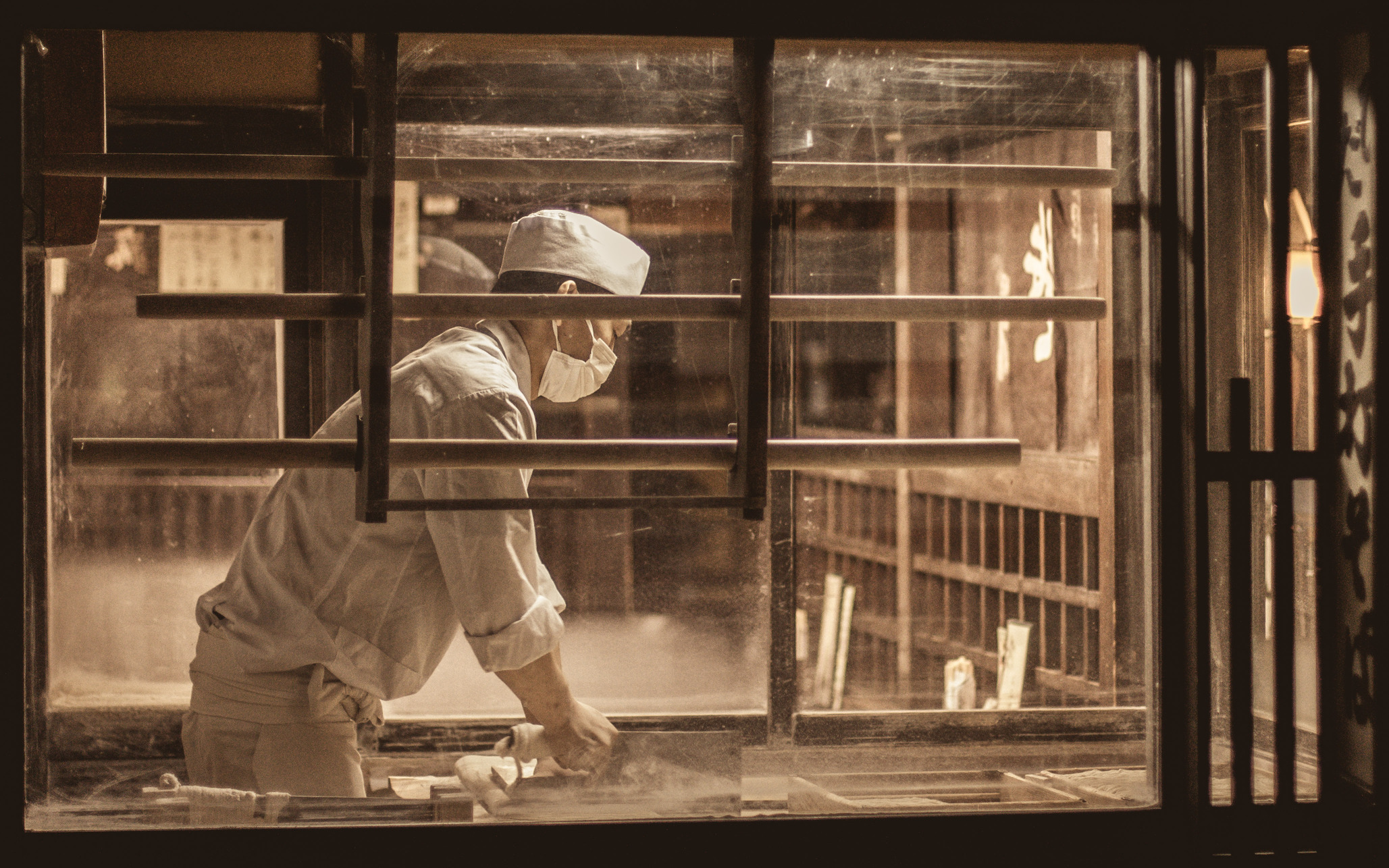 image of a chef making nooldes in the window